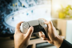 Mano de Gamer jugando con consola por el día mundial del gamer.